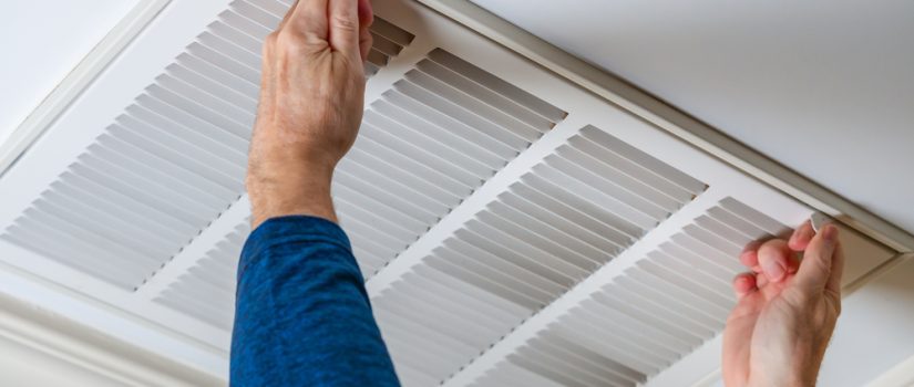 man cleaning ceiling vent