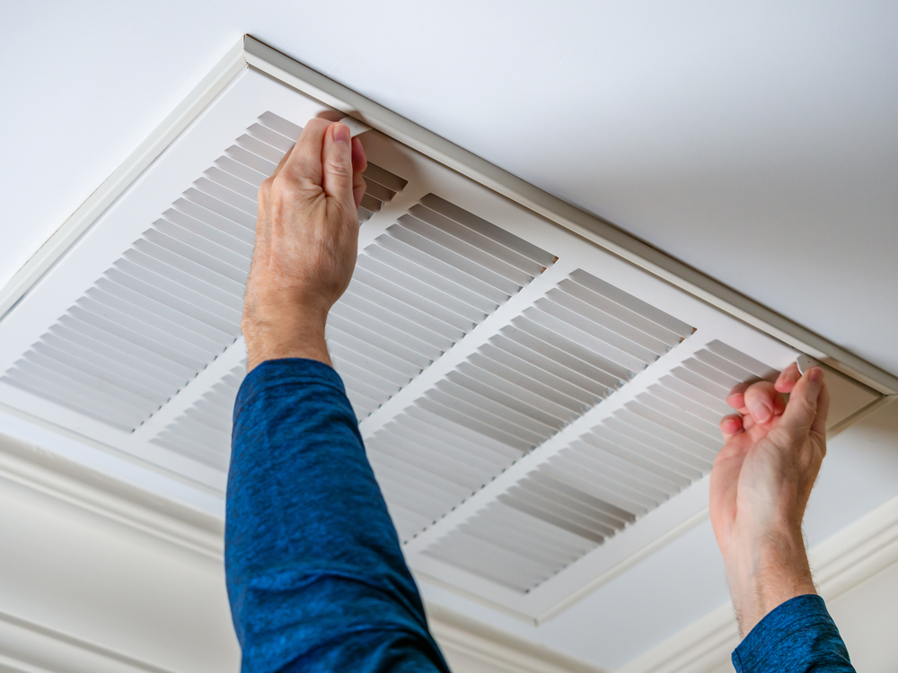 man cleaning ceiling vent